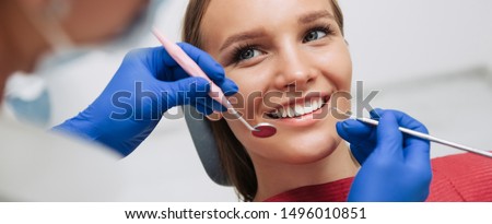 Beautiful young woman having dental treatment at dentist's office. Royalty-Free Stock Photo #1496010851