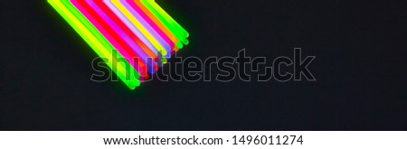 New colors of glow sticks for night party, on black background. Panoramic banner size