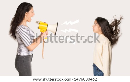 Furious mother shouting at girl through loudspeaker over light background, side view