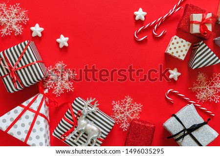 Christmas flat lay top view, gifts in different wrappers boxes on a red background, festive decor copy space