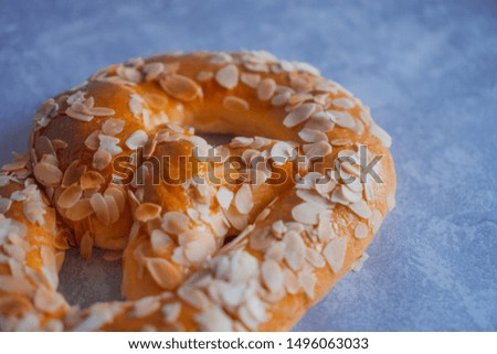 Abstract pastry background. Unfocused freshly baked homemade soft pretzel with almond petals on rustic table. Perfect for October fest. German cuisine. Negative space.