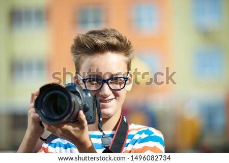 Funny teen boy with digital photo camera