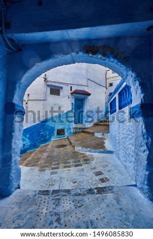 Blue doors, buildings and alley. Street photo taken on a rainy day in Chefchaouen, Morocco, North Africa