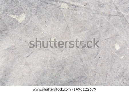Close view of a muslin drop cloth with off white paint spills and splotches. Royalty-Free Stock Photo #1496122679