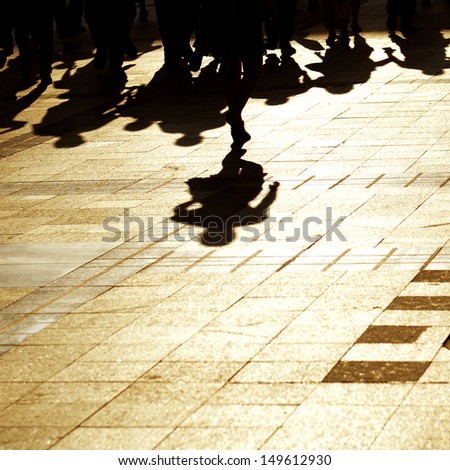 shadow of group of people walking on pavement.