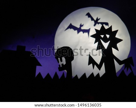 Dark Halloween season background with moon in the background and scary creatures silhouettes. Alien scull, bats, and funny monster.