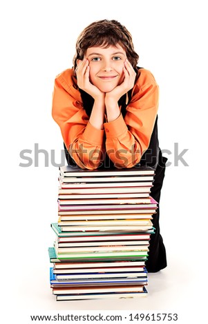 Happy schoolboy sitting with a stack of books. Isolated over white.