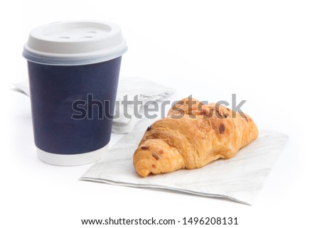 dark blue paper coffee cup with a croissant on a napkin