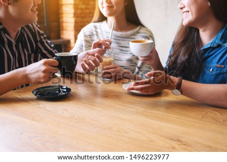 Closeup image of three people enjoyed talking and drinking coffee together in cafe