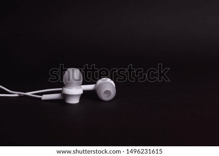 White headphones on a dark background  with copyspace close up.