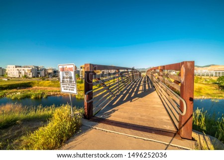 Bridge over a lake with view of buildings mountain and blue sky on a sunny day