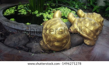 Golden turtle statue near the pond in the garden.