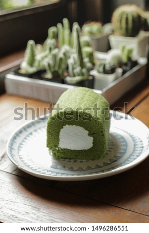 Green tea roll, green tea matcha dessert, Japanese sweet wth soft bread and sweet creamy on plate in coffee shop.