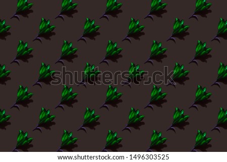 Emerald lilies on dark background trend flat lay concept with fashionable toning. Many flowers pattern