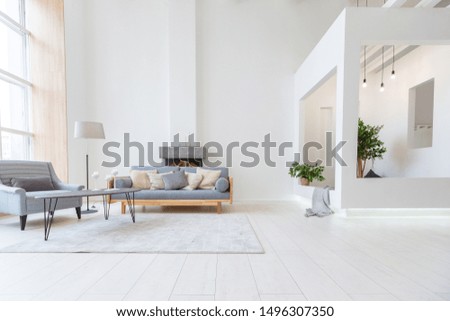 Luxury fashionable modern design studio apartment with a free layout in a minimal style. very bright huge spacious room with white walls and wooden elements. sitting area with fireplace Royalty-Free Stock Photo #1496307350