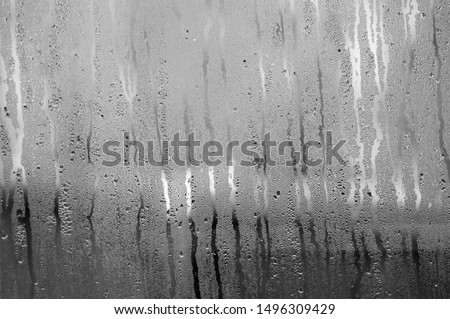 Transparent Glass with drops of water and can see through the glass outside but it is not clear. Vapour or steam on mirror when raining Royalty-Free Stock Photo #1496309429