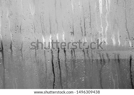 Transparent Glass with drops of water and can see through the glass outside but it is not clear. Vapour or steam on mirror when raining Royalty-Free Stock Photo #1496309438