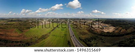 Aerial panorama of the summer landscape. Fields, meadows and road above. Russia, Leningrad region.