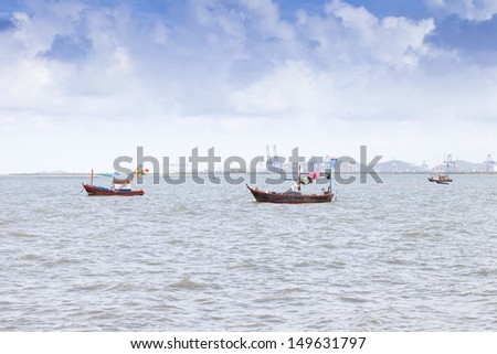 The beach with a blue sky and clouds , The sea, with boats parke
