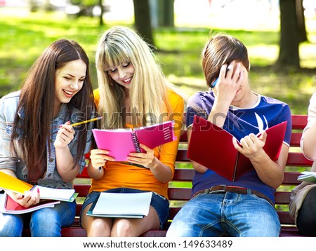 Group happy student with notebook on bench outdoor.