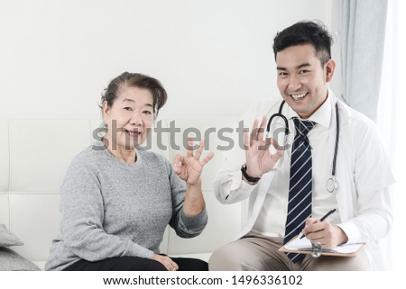 Asian doctor and senior patient with OKAY hands sign, health care concept.