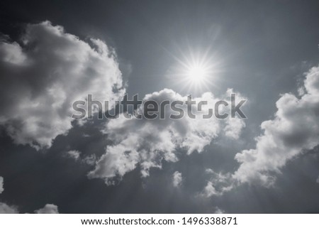 Black & white background - Angle view of beautiful natural sun ray & bright sunlight with lens flare on tropical sky & fluffy white clouds in tropical summer. Nature spectacular solar energy concept. Royalty-Free Stock Photo #1496338871