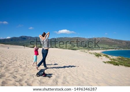 mother and her daughter, four years old girl, on top of the dune of Beach Valdevaqueros in Tarifa (Cadiz, Andalusia, Spain) practicing yoga exercises and gymnastics