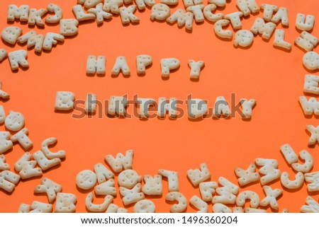 Happy birthday written by cookies on an orange background. Letters fonts from cookies. Bakery font.