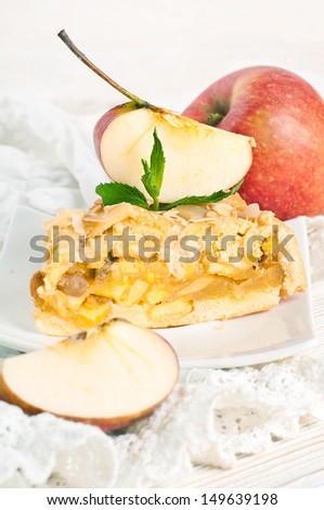 Apple pie and fresh apples on a white napkin