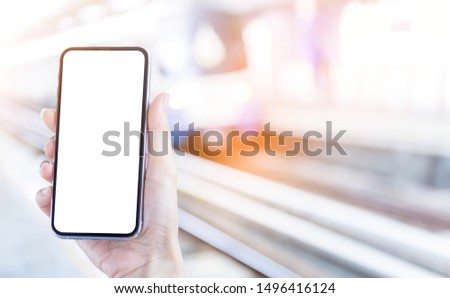 Mockup image blank white screen cell phone.woman hand holding texting using mobile at outdoor.background empty space for advertise text. contact business,people communication,technology 