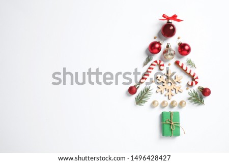 Christmas tree silhouette of fir branches and festive decoration on white background, top view