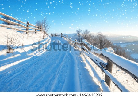 winter landscape. rural road covered with snow. mountainds on horizon