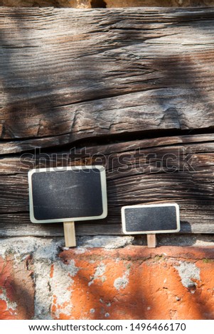 An information sign stands on a brick and wooden obsolete wall