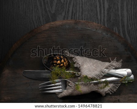 Christmas silverware at dark wooden table., with cone, Top view, copy space.
