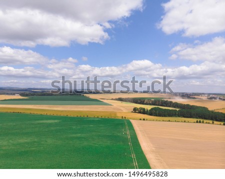 Aerial view of green and yellow harvest fields with car and beautiful road. village Czech Republic, summer sunny day, earth geometry, agriculture concept