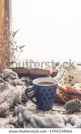 Coffee in a blue mug on the windowsill in autumn winter