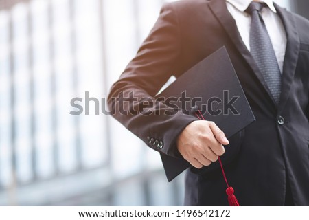 Graduates of the University, businessman holding hats along with success,  filter tone outdoor sunny in the morning. office background. New graduate start working on the first day. Education concept. Royalty-Free Stock Photo #1496542172