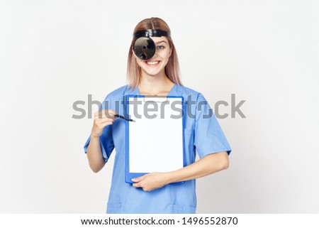 A beautiful woman with a medical tool in front of her face shows a folder with documents