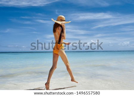 Beautiful woman in yellow swimsuit travel tropics beach