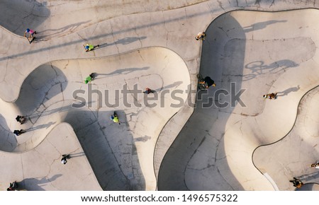 Skate park top view. Young people doing sport riding skaters bicycles and scooters. Aerial top view. Creative Stree photo new concept