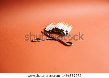 Scissors and cigarettes isolated on brown backgrounds