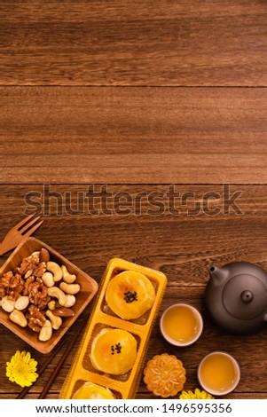 Mid-Autumn Festival holiday concept design of moon cake, mooncakes, tea set on dark wooden table with copy space, top view, flat lay, overhead shot
