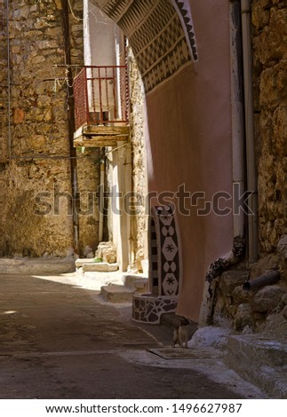 Narrow alley with decorated faucet sink, in Pyrgi  medieval village, Chios island, Greece.
