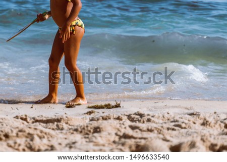 little girl playing beach tennis on vacation on sandy beach near ocean/sea. travel with kids. children day. copy space.