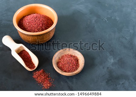 Sumak - a spice from the ground berries of one of the types of sumac reddish-burgundy with a sour taste. It is used in Turkish and Levantine cuisine for salad dressing. Royalty-Free Stock Photo #1496649884
