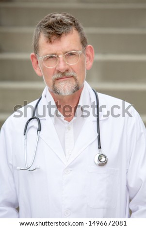 portrait of handsome doctor in his 50s standing outside