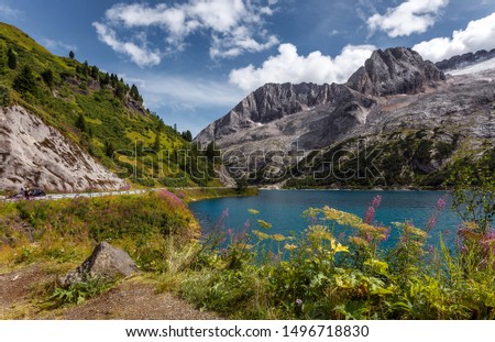  Amazing natural scenery in Dolomites Alps.  Summer view of  Fedaia lake and Marmolada mountain. Picture of wild area. Awesome alpine highland in sunny day