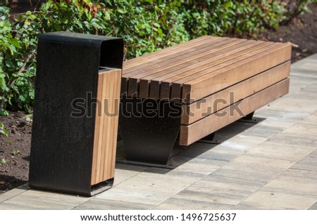 Bench with an urn stands in a park.