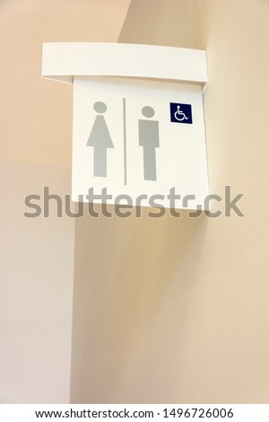 Modern public toilet sign hanging on the wall