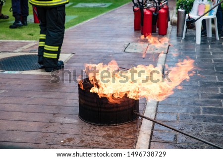 Fire in steel bucket for demonstrate to extinguish fire with fireman 